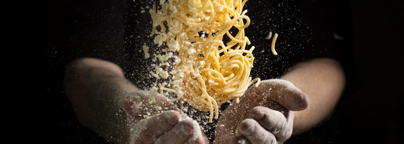 close hand make pasta toss f on a black background before cooking the dish